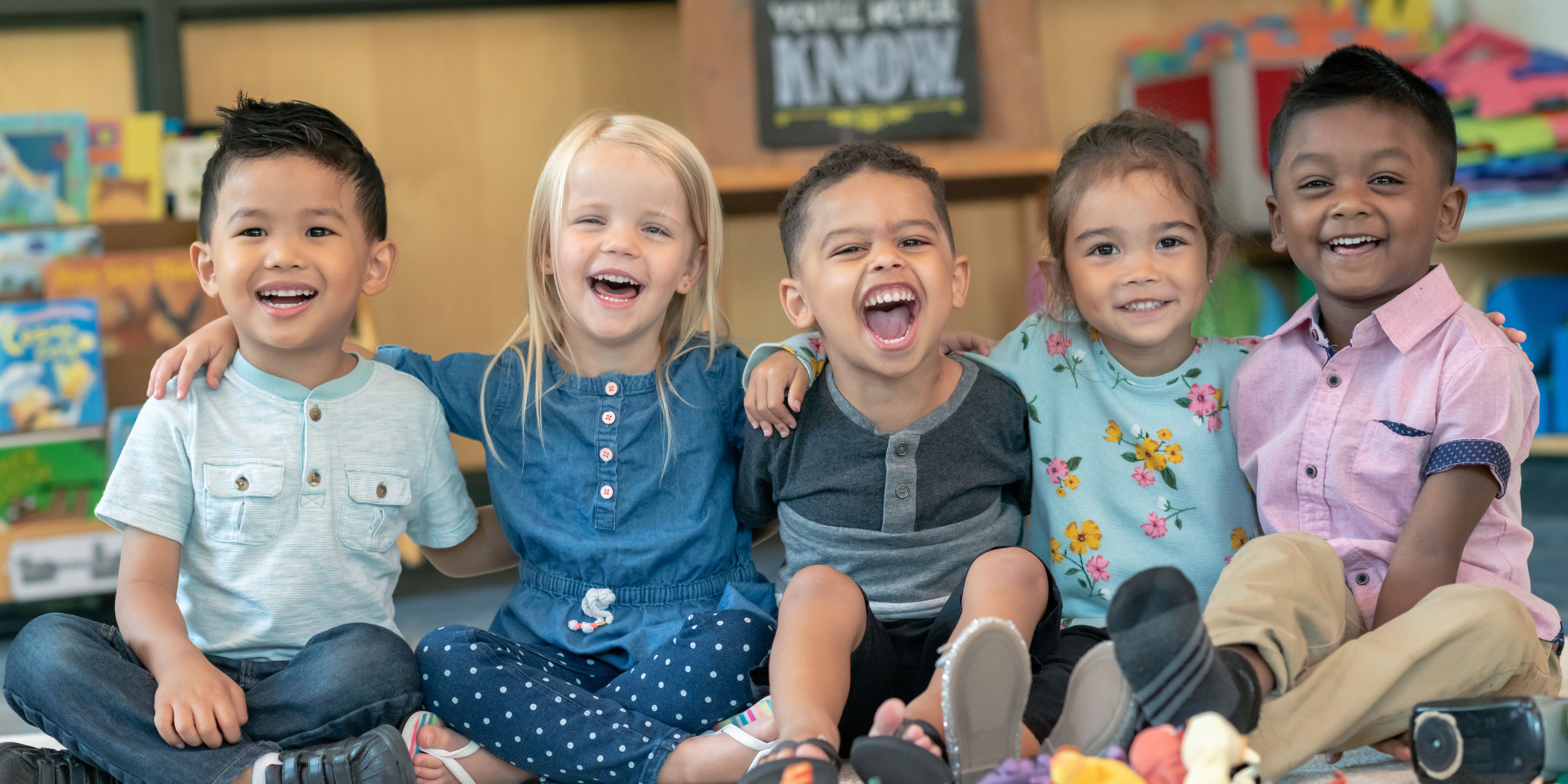 A group of diverse children laying on the ground in a circle