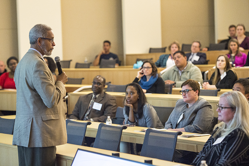 Dr. Norm Oliver speaks to a group of people in an auditorium