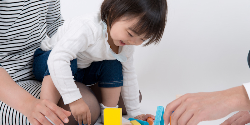 A little girl playing with building blocks