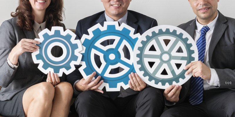 3 people holding 3 gears